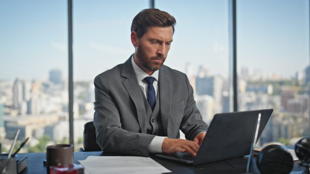 Focused director working computer analysing report data. Office manager typing